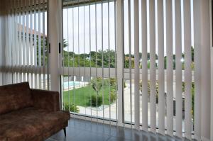 sala de estar con ventanas grandes y sofá en Garda Bloom Holiday Apartments, en Padenghe sul Garda