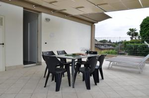 una mesa de comedor negra y sillas en un patio en Garda Bloom Holiday Apartments, en Padenghe sul Garda