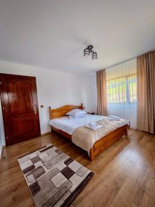 a bedroom with a bed and a rug on the floor at Casa BiaFlor in Rucăr
