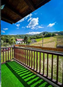 uma vista da varanda de uma casa com relva verde em Casa BiaFlor em Rucăr