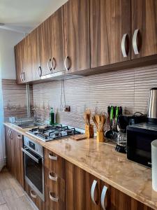 a kitchen with wooden cabinets and a stove top oven at Casa BiaFlor in Rucăr