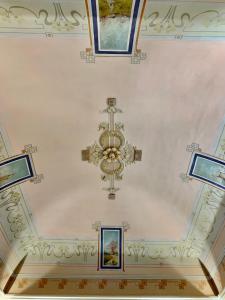 カターニアにあるLa Renaissanceの天井にシャンデリアと絵画が飾られている