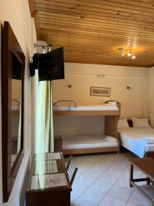 a room with two beds and a table and a tv at Villa Agni in Yénion