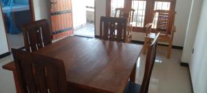 comedor con mesa de madera y sillas en Galle City Nest en Galle