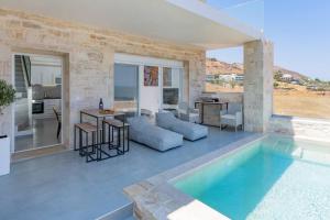a villa with a swimming pool and a living room at Sofia Suite, a seafront hideaway ! in Panormos Rethymno