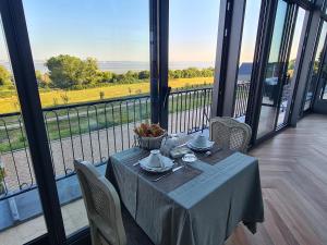 une table dans une pièce avec vue sur un champ dans l'établissement La Terrasse de l'Estuaire - Honfleur, à Honfleur