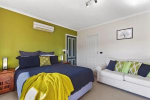 a bedroom with a bed and a couch at Stay Inn in Apollo Bay