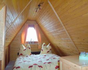 a bedroom with a bed in a wooden attic at Ferienhaus Busch in Bünsdorf