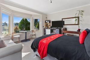 a bedroom with a bed and a desk and a couch at Stay Inn in Apollo Bay