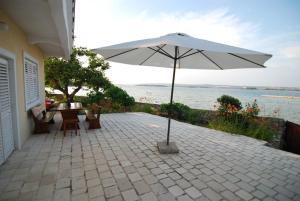 a patio with an umbrella and a table and chairs at Apartments Kraj, Tratica Beach in Kraj