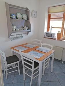 een keuken met een tafel en stoelen en een magnetron bij Ferienwohnung "Luv" Grube Ostsee in Grube