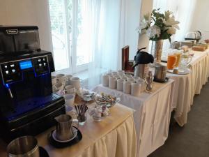 una fila de mesas con tazas y platos. en Hotel PAYER en Teplice