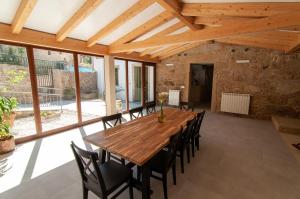 comedor grande con mesa de madera y sillas en A Casa Do Boi, en Amés