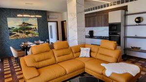 a living room with a couch and a kitchen at I Due Grifoni Luxury Apartment & Spa in Taormina