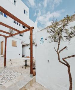 un patio con un árbol junto a un edificio blanco en Casa Leonor Vejer, en Vejer de la Frontera