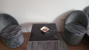 two chairs and a table with a small bowl on it at Sleep and drive 2 in Sarajevo