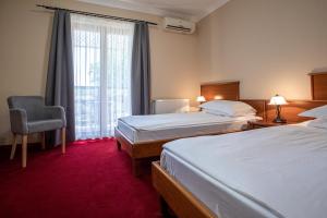 a hotel room with two beds and a window at Hotel Vila Lago in Palić