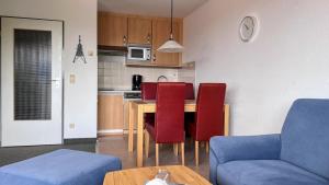 cocina con mesa y sillas rojas en una habitación en Haus Trafalgar Whg. 242 Möwennest, en Cuxhaven