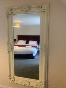 a mirror reflecting a bed in a bedroom at Church View in Kirk Yetholm