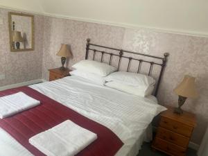 a bedroom with a large bed with a red and white blanket at Church View in Kirk Yetholm