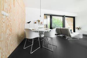 une salle à manger avec une table blanche et des chaises blanches dans l'établissement White Innk city center apartment, à Trnava