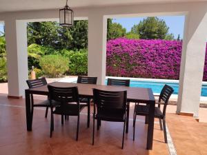 a dining room with a table and chairs next to a pool at Villa with Private Pool, BBQ, Fitness Center & Sauna in San Vicente del Raspeig