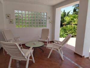 a room with chairs and a table and a window at Villa with Private Pool, BBQ, Fitness Center & Sauna in San Vicente del Raspeig
