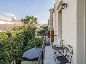 a balcony with an umbrella and a table and chairs at Cretan Berry Kondylaki in Chania Town