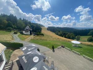 eine Luftansicht eines Hauses mit zwei Sonnenschirmen in der Unterkunft Berghotel Lenneplätze Winterberg in Winterberg