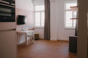 a small room with a desk and two windows at Maximilian Studios in Speyer
