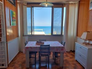 - une salle à manger avec une table et une vue sur l'océan dans l'établissement Sunset Apartment, à Santa Marinella