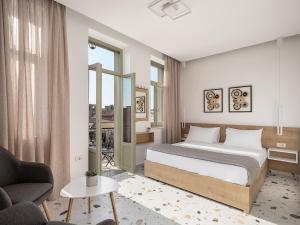 a bedroom with a bed and a couch and a chair at Cretan Berry Kondylaki in Chania