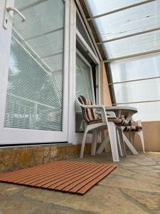 a porch with a table and a chair and a window at Apartment Grcic in Sarajevo
