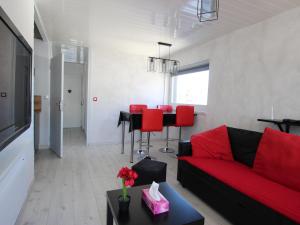 a living room with a red couch and a table at Appartement Chamrousse, 2 pièces, 4 personnes - FR-1-340-259 in Chamrousse