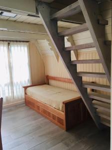 a bedroom with a bed and a staircase at Cabañas Chapelco in San Martín de los Andes