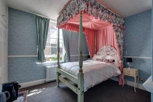 ein Schlafzimmer mit einem Himmelbett und einem Fenster in der Unterkunft Stone Court House in Maidstone