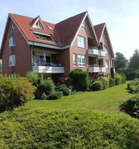 una gran casa de ladrillo con un patio verde en BUPA06107-FeWo-Passat-soess, en Burg auf Fehmarn