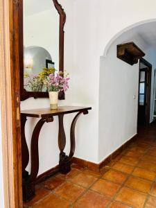 a table with a mirror and flowers on it at Villa ALJARAL, Espectacular,piscina,chimenea, climatización, wifi in Córdoba