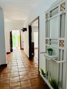 a hallway with a mirror and a tile floor at Villa ALJARAL, Espectacular,piscina,chimenea, climatización, wifi in Córdoba
