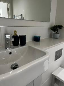 a white sink in a bathroom with a mirror at Modern Suite- Bedford City centre with free gym & parking in Bedford