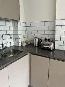 a kitchen with a sink and a counter top at Modern Suite- Bedford City centre with free gym & parking in Bedford