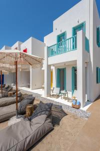 a large white building with a patio in front of it at KLIMA BAY Beachfront Boutique Houses in Klima