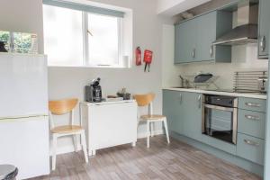 a kitchen with blue and white cabinets and wooden floors at Remarkable 1-Bed Apartment in Ulverston in Ulverston