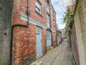 un callejón con un edificio de ladrillo con dos puertas de garaje en Remarkable 1-Bed Apartment in Ulverston en Ulverston