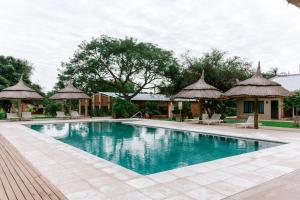 a swimming pool with umbrellas and a resort at Confratelli Cabañas in Paso de la Patria