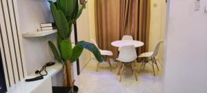 a room with a table and chairs and a plant at Modern & Cheerful 2 Bedroom Villa, Alagbaka in Akure