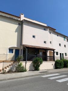 a large white building with a balcony on a street at Appartement rue de l'amarrage à PORT GRIMAUD avec Terrasse vue canaux et garage in Grimaud