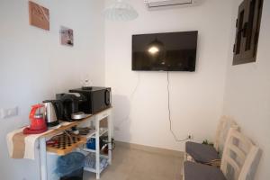 a room with a table with a tv on the wall at SGM CASA VACANZE in Masainas