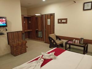 a hotel room with a bed and a tv at DIDI Hotel Alambagh in Lucknow