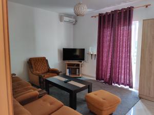 sala de estar con sofá y TV en Apartments BEA, en Ulcinj